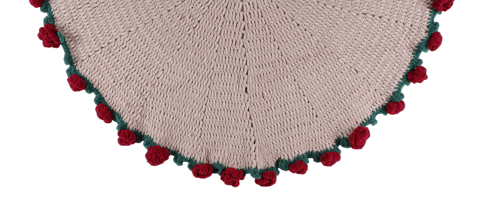Heart-shaped knitted item with red and green pom-poms on a white background