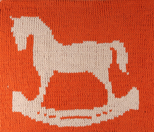 Knitted square with a white cat horse rocker on an orange background