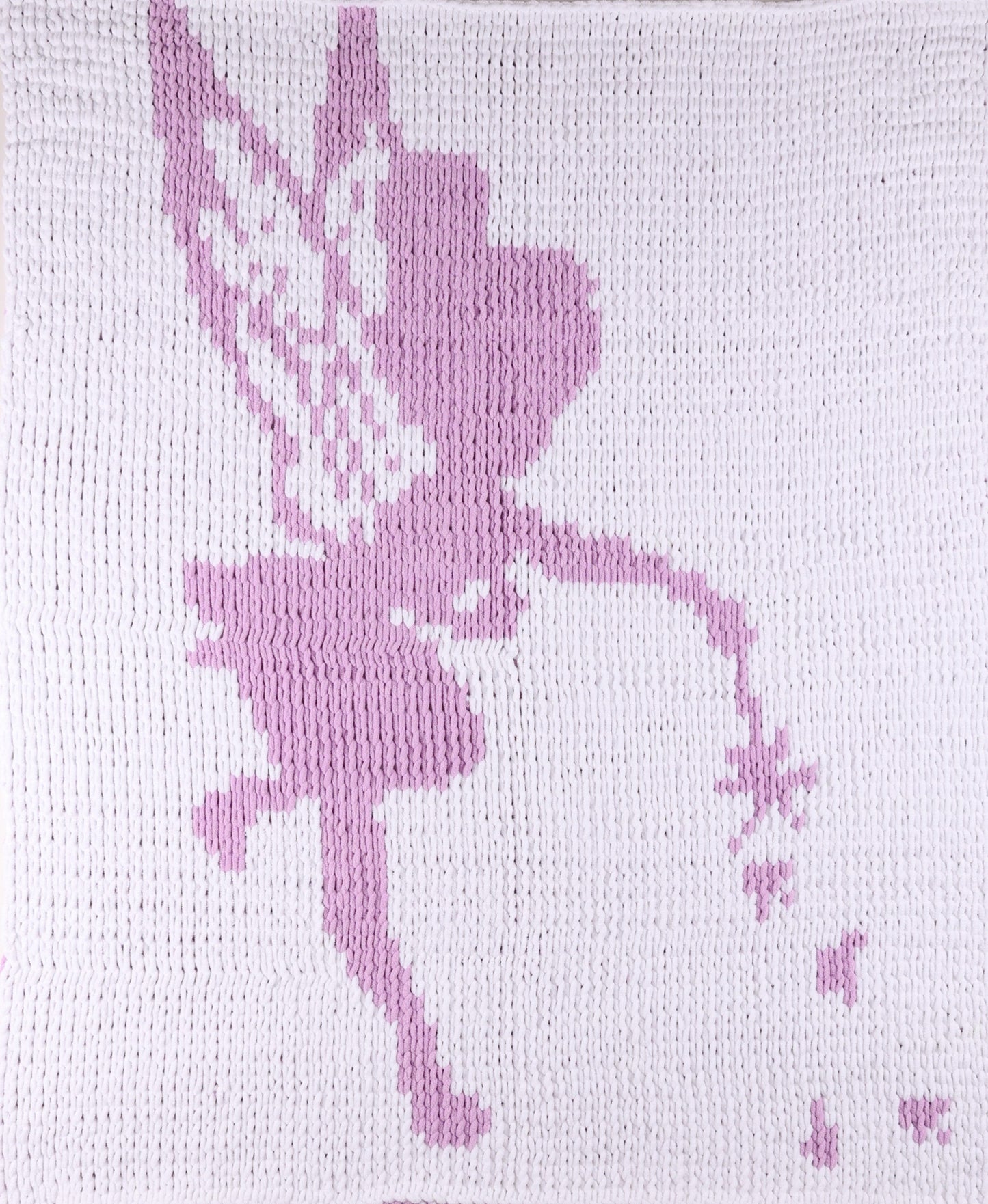 White knitted blanket with a purple tinkle bell design 