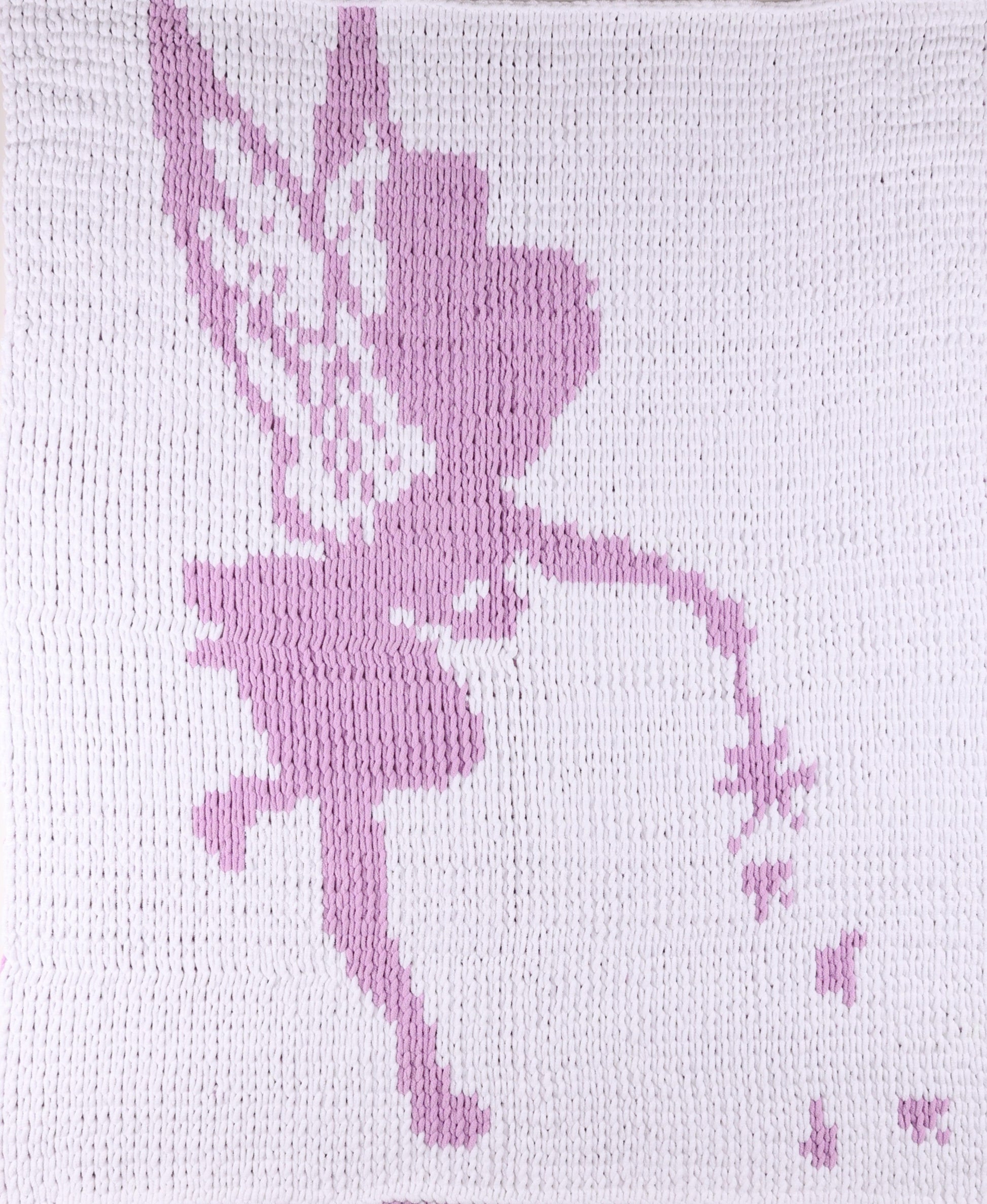 White knitted blanket with a purple tinkle bell design 